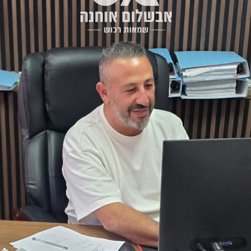 אבשלום אוחנה יושב במשרד מול מחשב ועושה דוח שמאי רכוש
